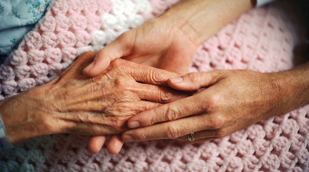 Caregiver holding the hands of a resident